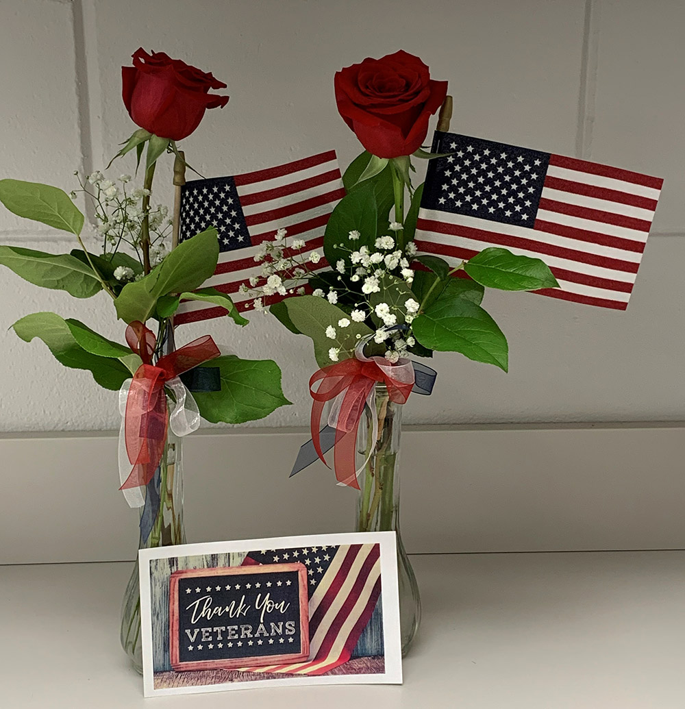 Rosas en un jarrón con una bandera americana.